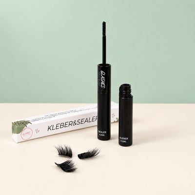 Glashes schwarzer Wimpernkleber und transparenter Sealer mit Verpackung