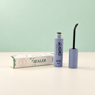 Glashes grauer Sealer mit geöffnetem Bürstchen und Verpackung